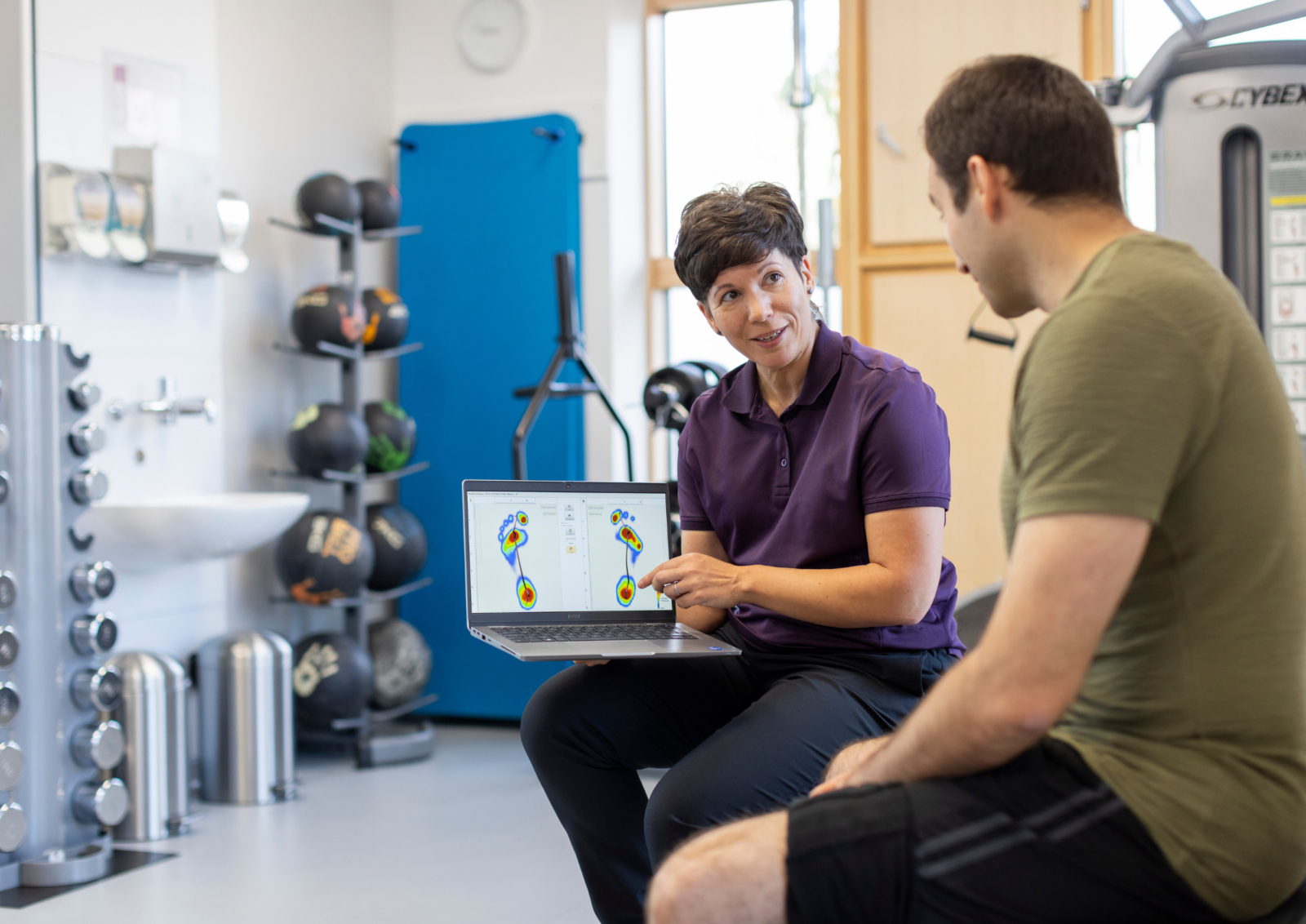 Amanda Marsh showing a patient the results of their weight distribution and pressure test showing their balance and alignment